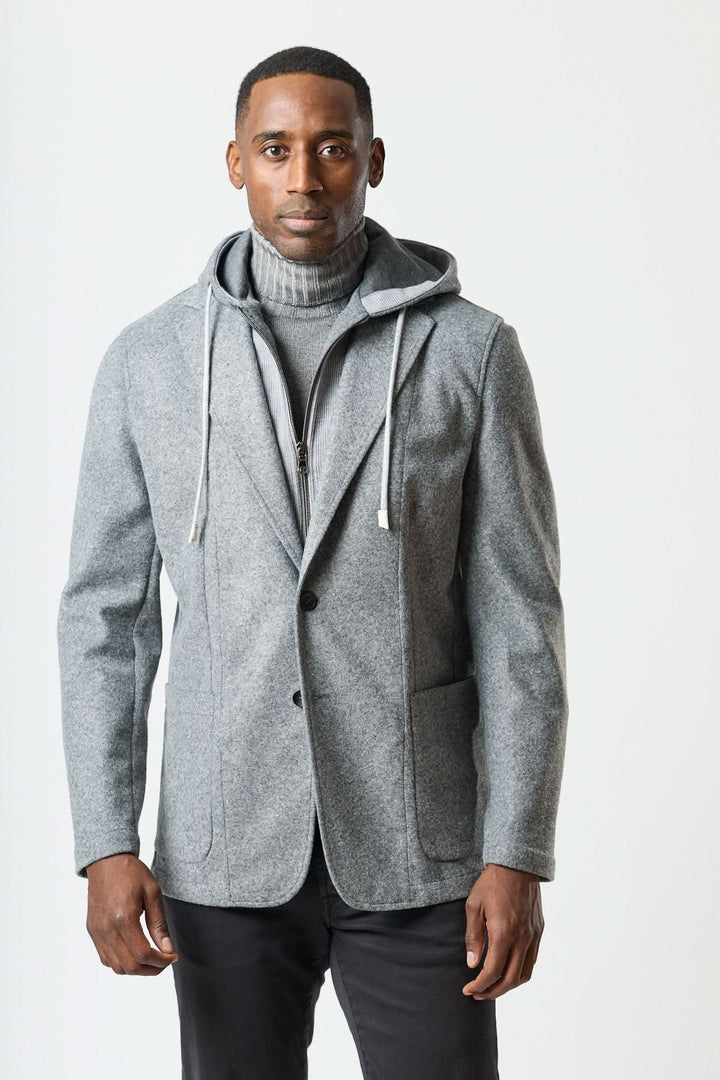 Veston hybride à capuche gris avec capuche intégrée, porté sur un col roulé gris pour un look urbain soigné.