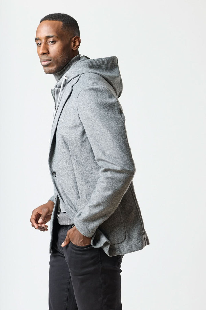 Veston hybride à capuche, confortable et élégant, parfait avec un col roulé et un denim sombre pour un look urbain moderne.