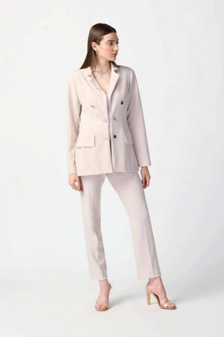 Veston long double boutonnière en tricot soyeux, style contemporain avec col cranté et silhouette ajustée.
