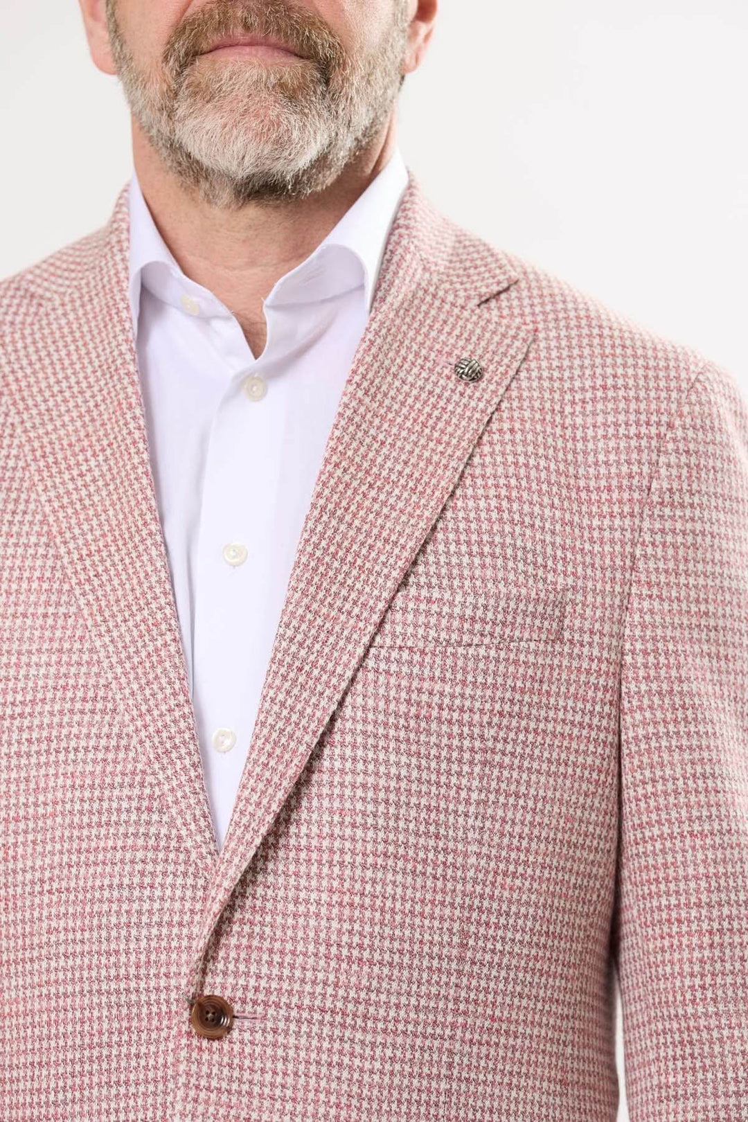 Veston motif pied-de-poule bicolore pour un look chic, élégant et raffiné, avec poches à rabat et boutonnière décorative.
