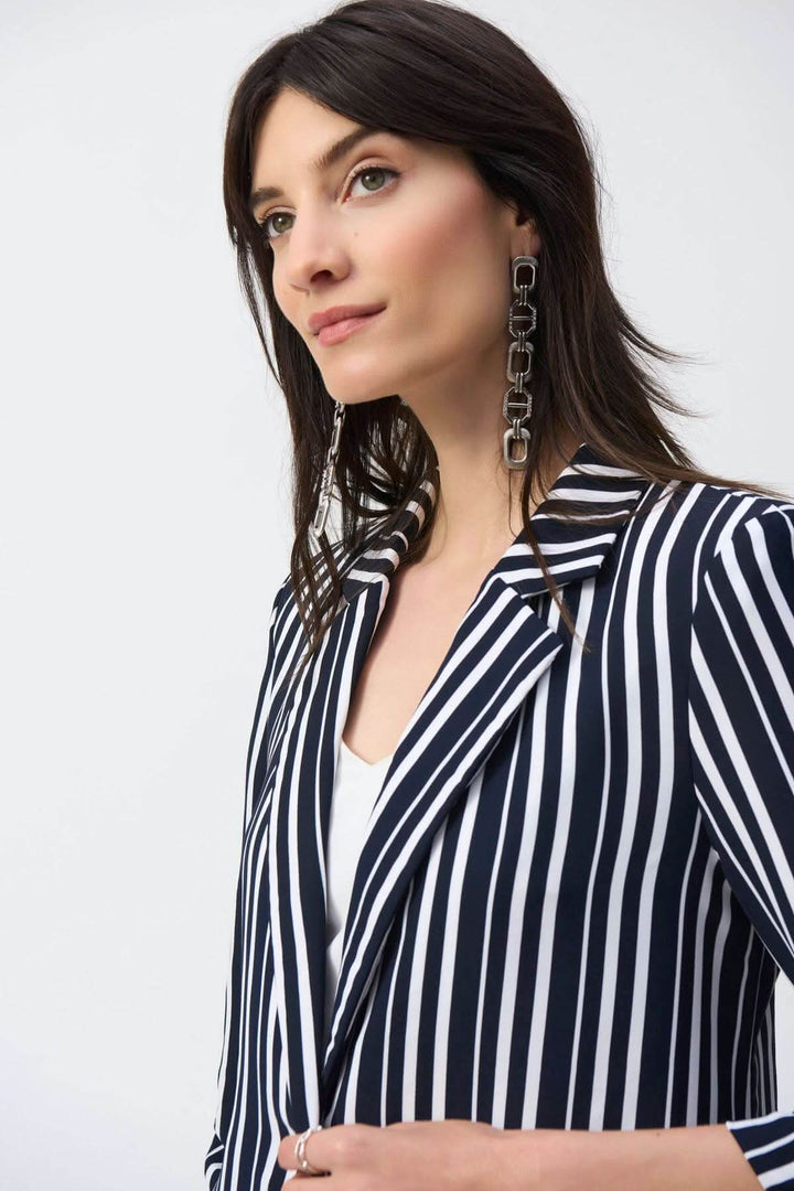 Femme portant un veston rayé léger avec col cranté et manches 3/4, style élégant et décontracté.