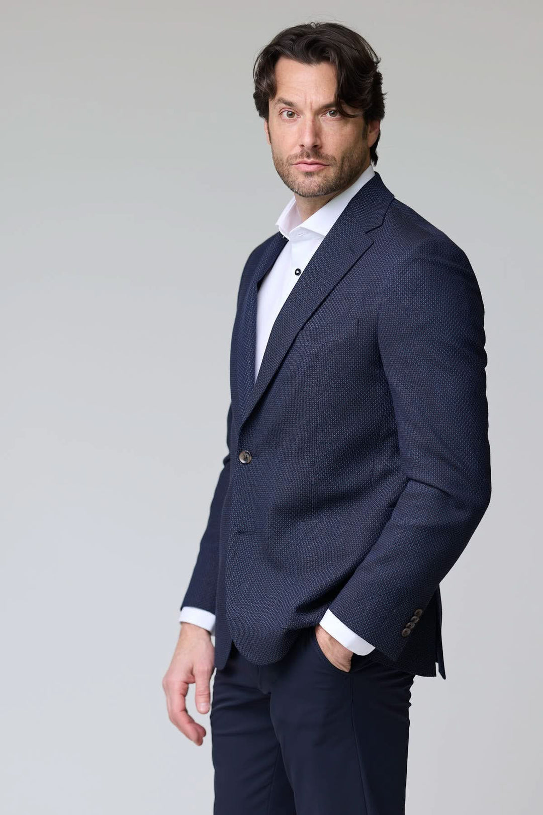 Veston texturé à coupe moderne porté par un homme, idéal pour le bureau et les sorties habillées, tissu élégant et souple.