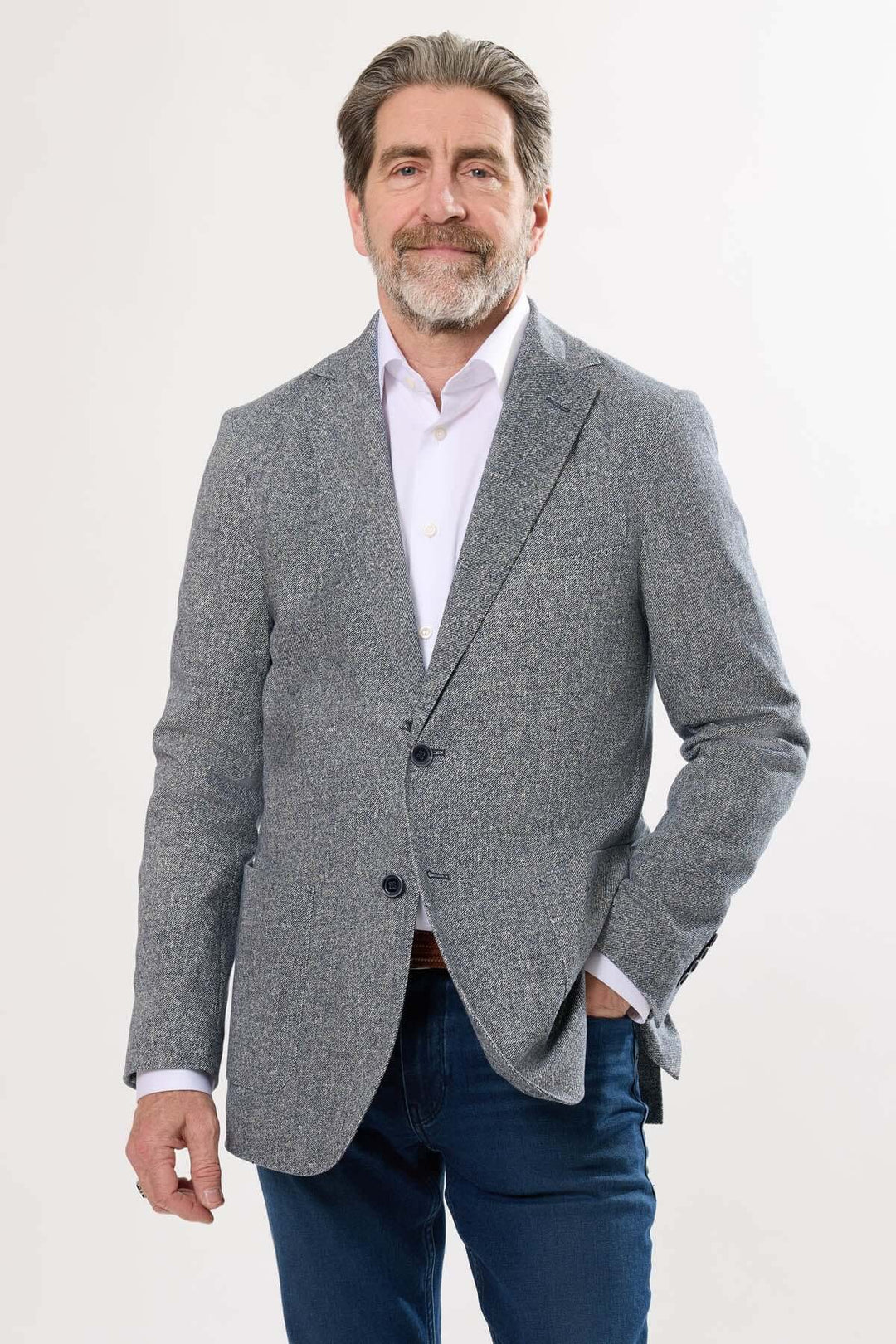 Homme portant un veston à texture subtile, élégant et décontracté, parfait pour les occasions estivales.