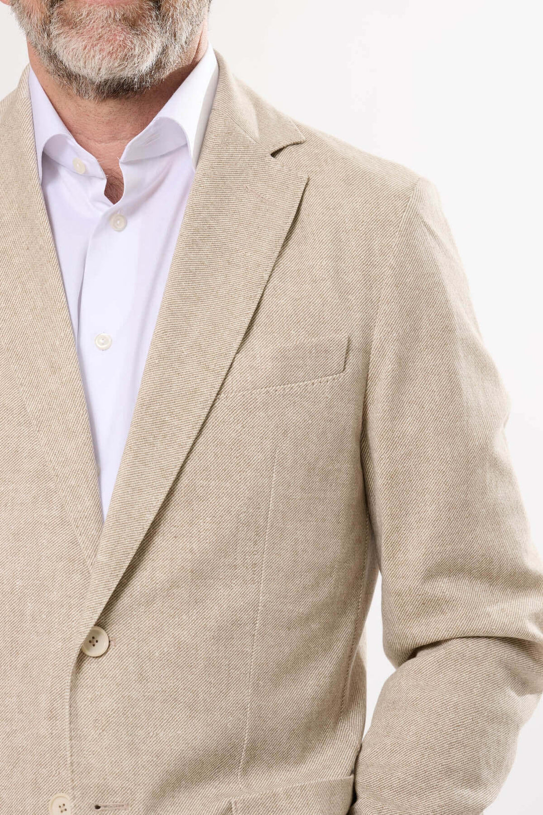 Homme portant un veston à texture subtile, élégant et léger, idéal pour les occasions estivales.