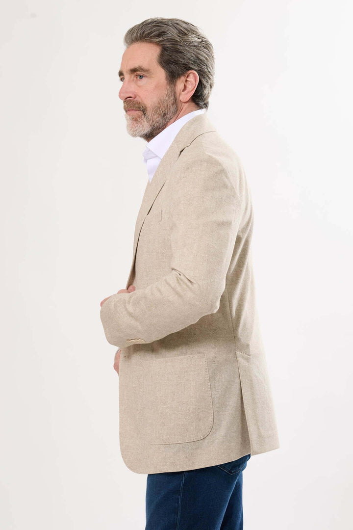 Homme portant un veston beige à texture subtile, idéal pour le chic décontracté et les occasions estivales.