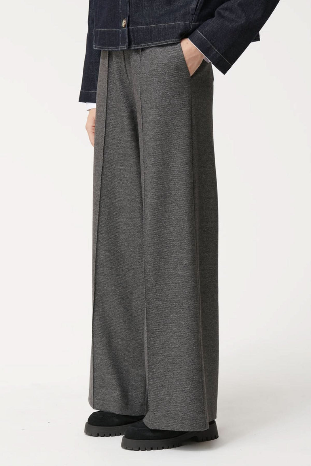 Pantalon ample à la coupe fluide avec taille élastiquée et plis marqués, offrant confort et élégance, poches latérales visibles.