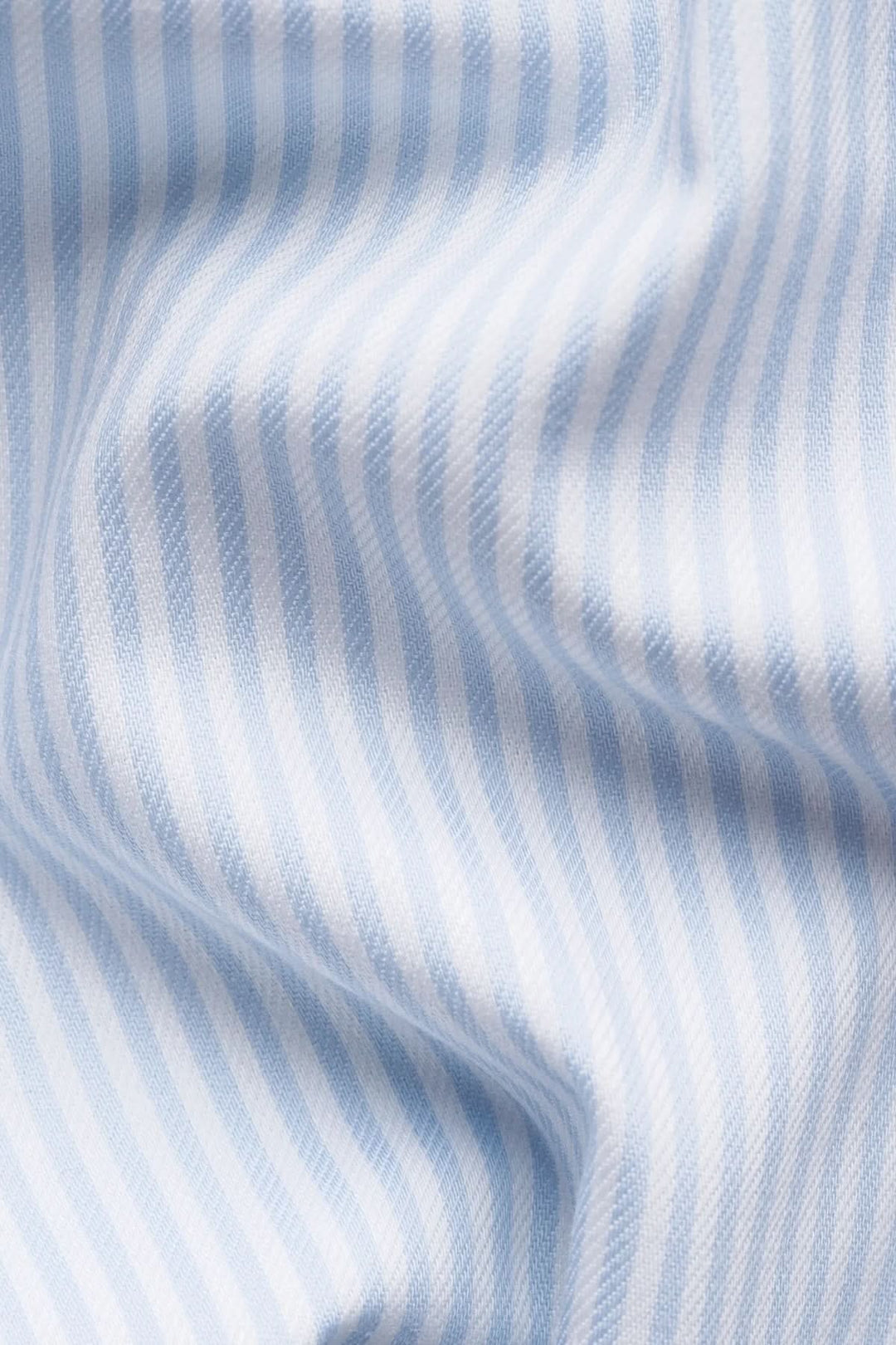 Chemise rayée en coton et lyocell avec fines rayures bleues, texture fluide et élégante pour un style raffiné et confortable.