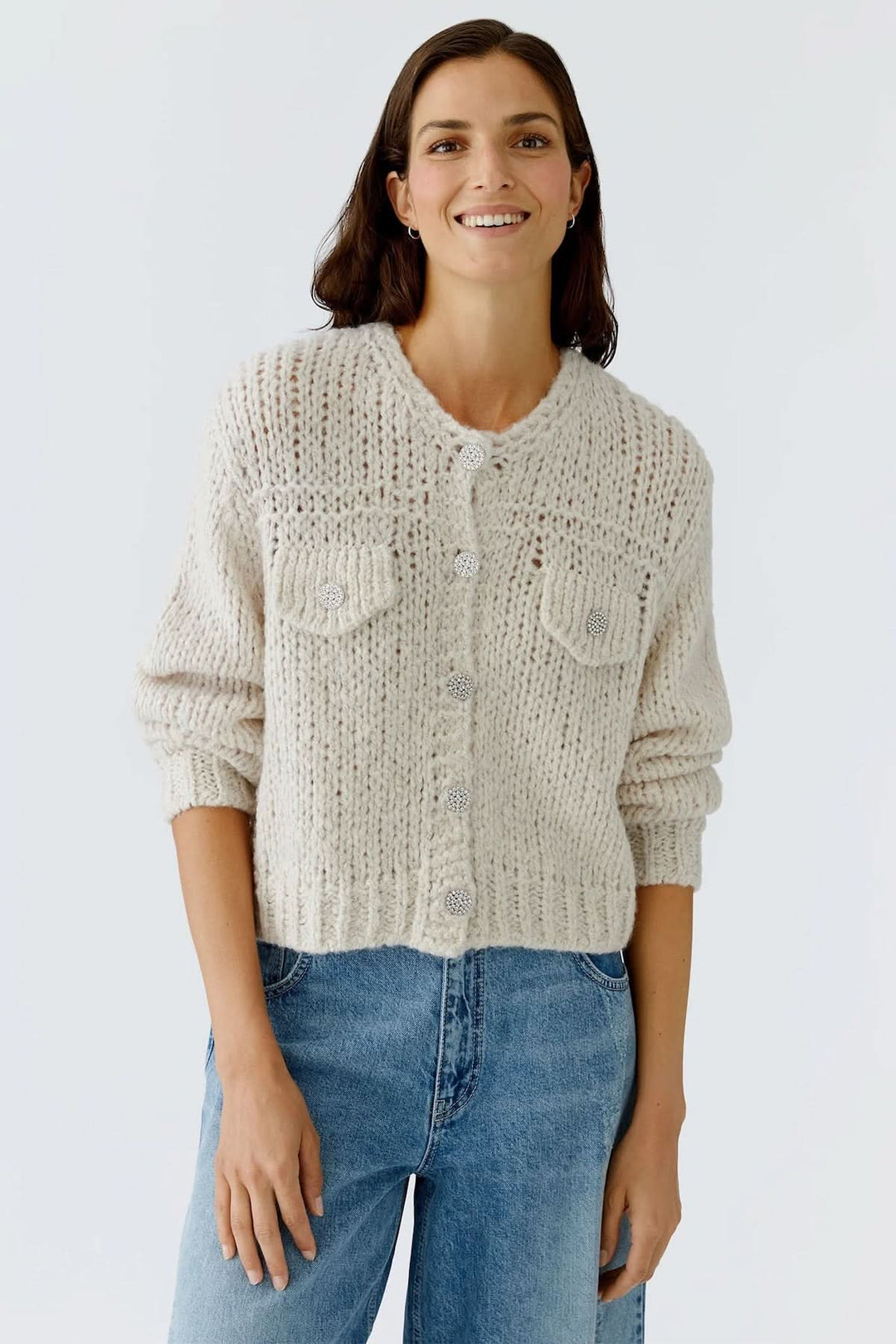 Femme portant une veste en tricot épais à boutons bijoux, style décontracté automne hiver.