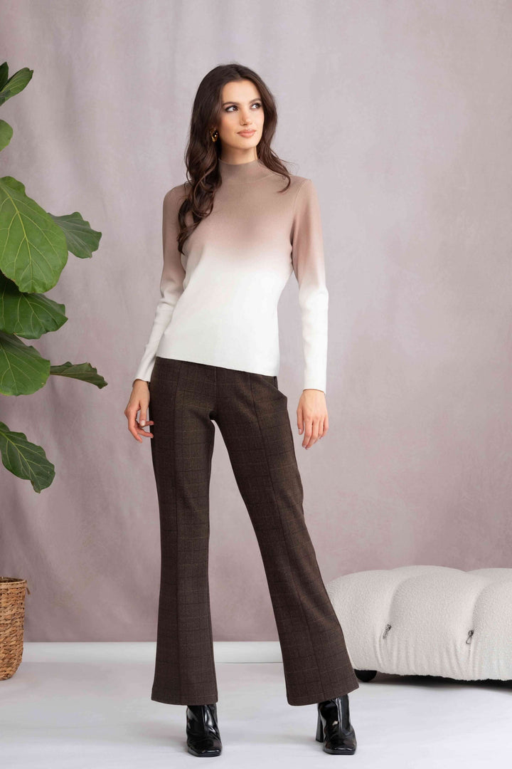 Tricot col montant dégradé en beige et blanc, porté avec pantalon marron pour un look élégant.