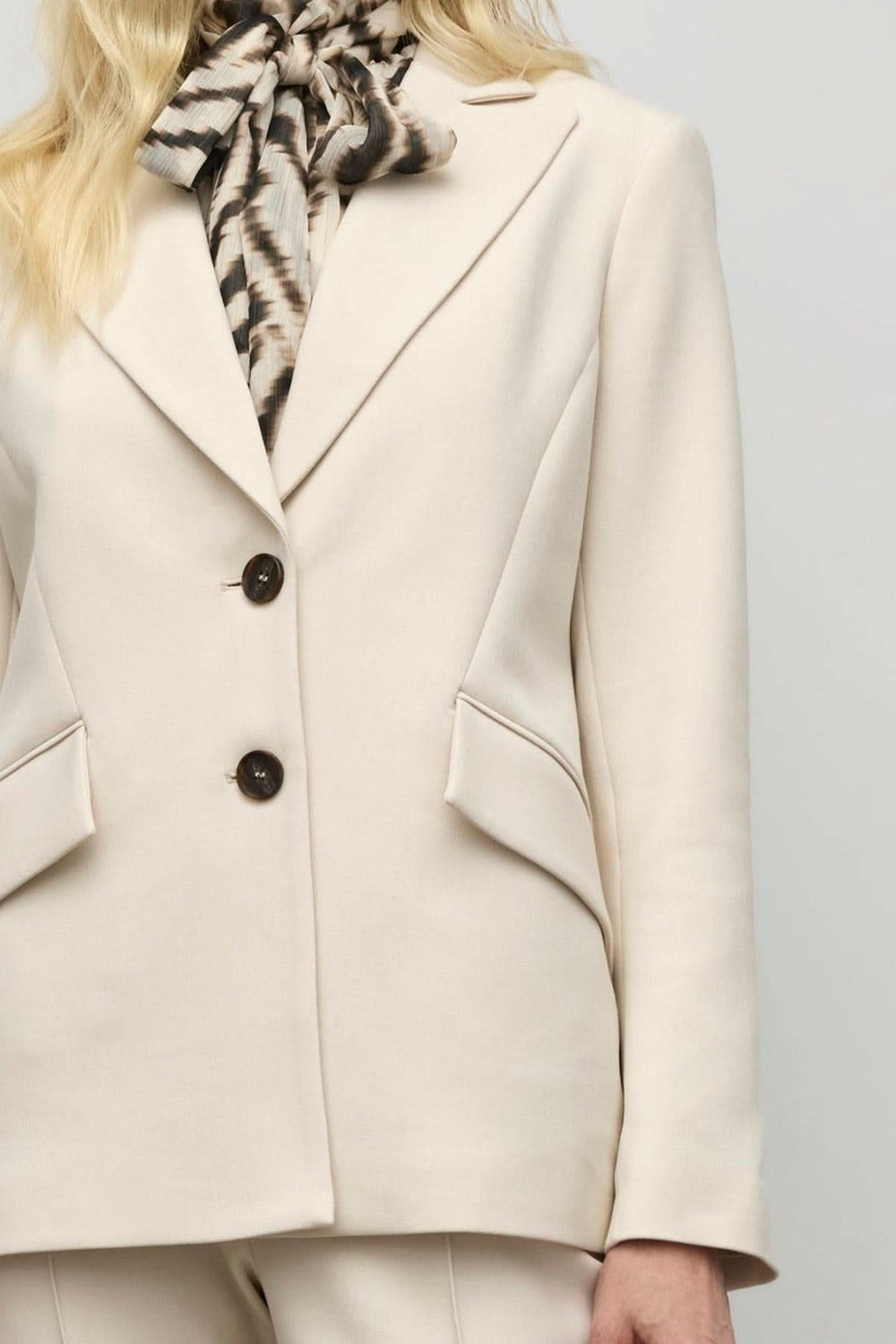 Veston semi-ajusté beige à deux boutons, porté avec un foulard élégant, pour un style chic et professionnel.