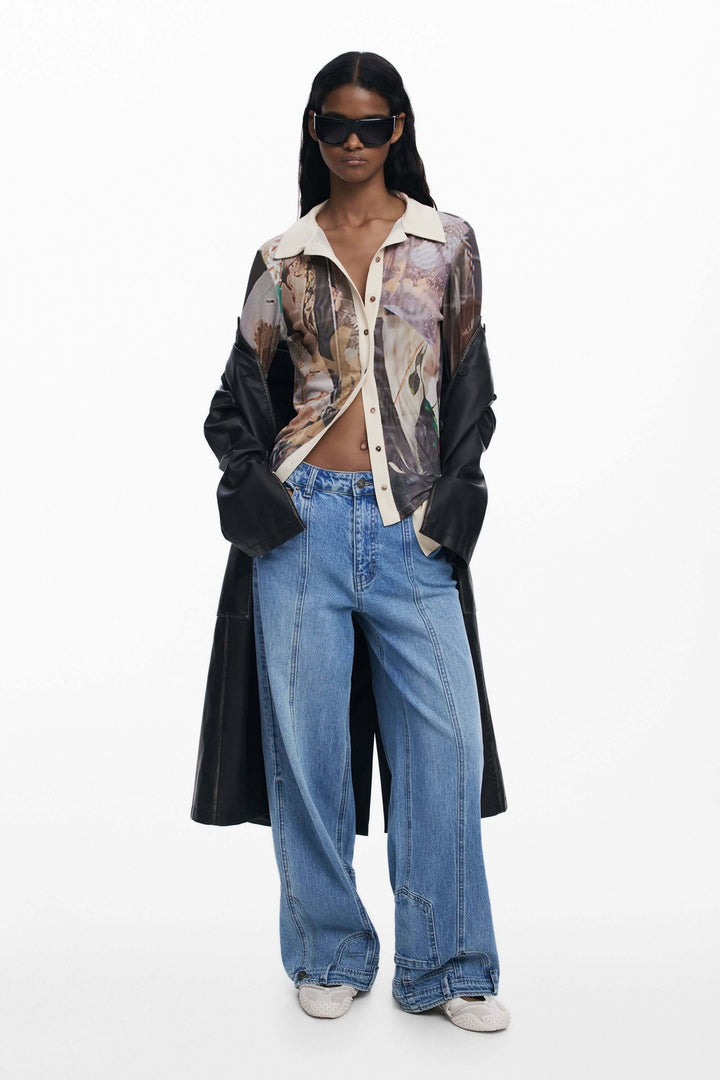 Modèle portant un T-shirt en mousseline avec poignets, aux imprimés artistiques, associé à un jean décontracté et un trench-coat.