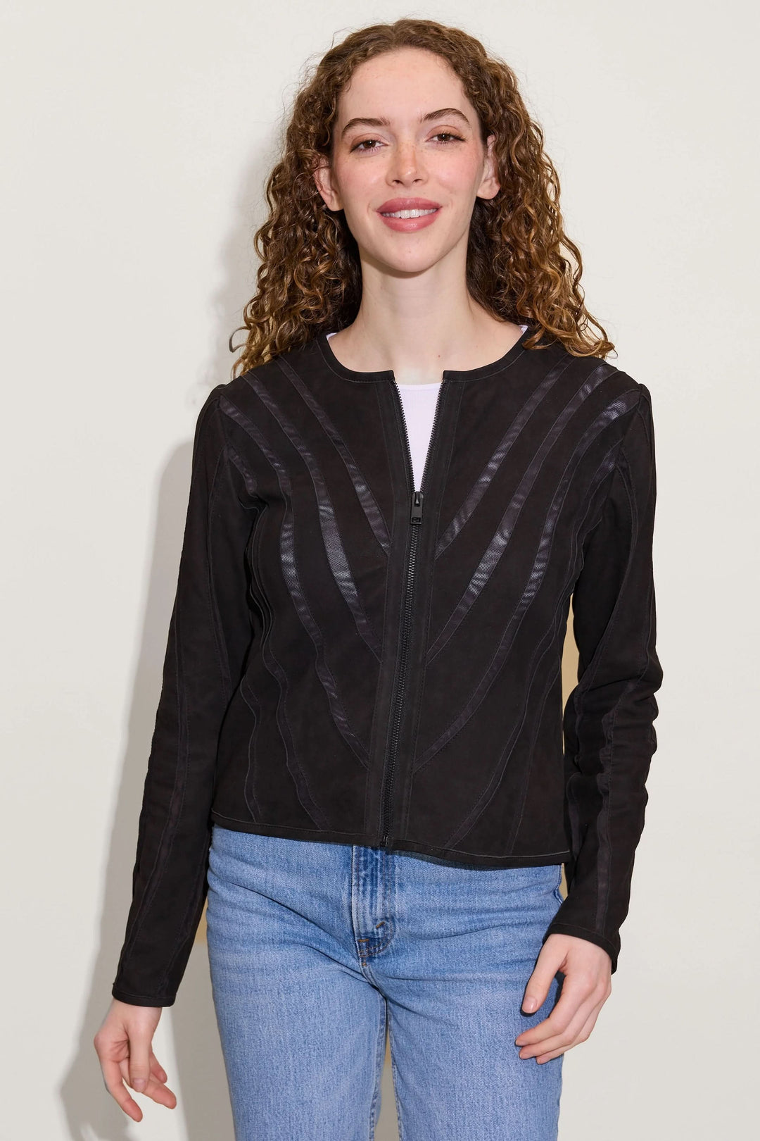Femme portant un Manteau Mira en cuir avec découpes graphiques et col rond, style moderne et minimaliste.