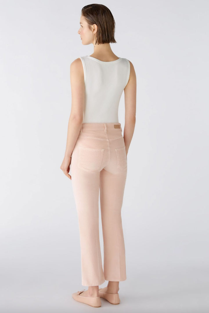 Pantalon en velours côtelé légèrement évasé, taille moyenne, vue arrière, couleur pêche, style décontracté.