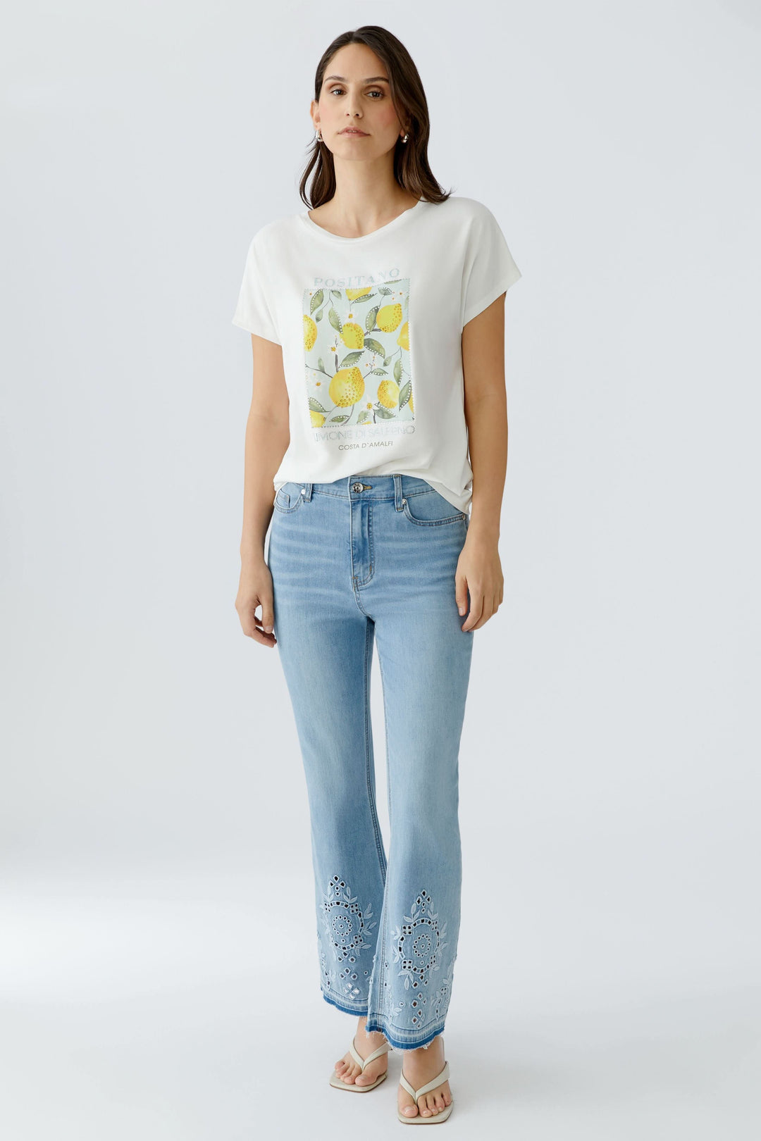 Femme portant un t-shirt imprimé à manches courtes avec motif graphique et jeans pour un look décontracté.
