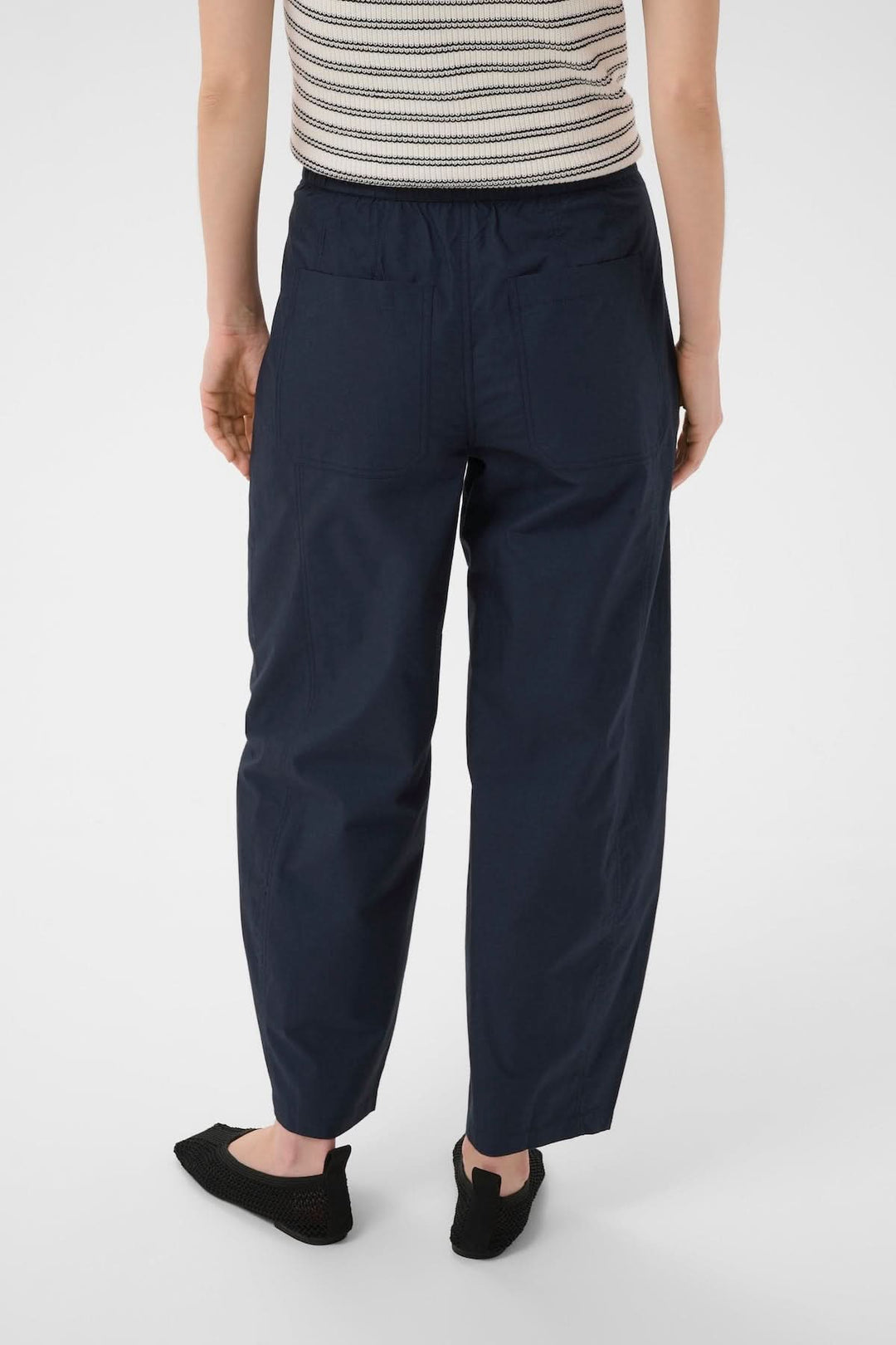 Vue arrière du Pantalon Atimas, coupe large et silhouette contemporaine, confortable avec poches latérales. Description en français incluse.