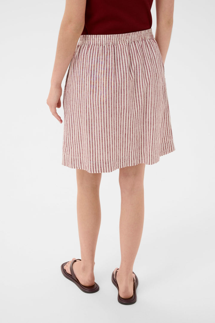 Jupe Birgitt à rayures taille élastiquée avec coupe droite et poches latérales, vue arrière portée avec débardeur rouge et sandales noires.