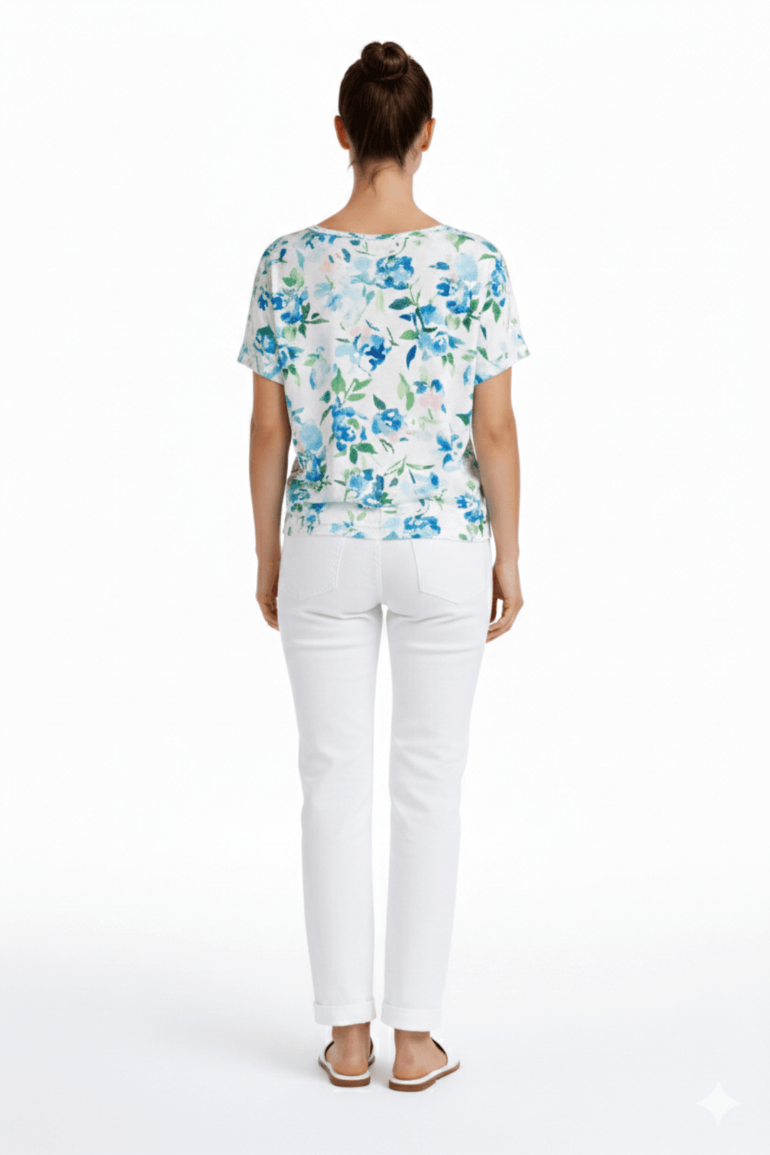 Jeans coupe droite blanc avec longueur écourtée, portés avec un haut à motifs bleus pour un look décontracté.