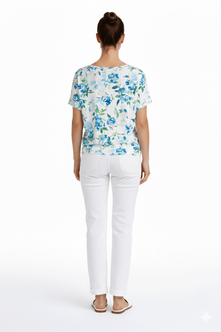 Jeans coupe droite blanc avec longueur écourtée, portés avec un haut à motifs bleus pour un look décontracté.