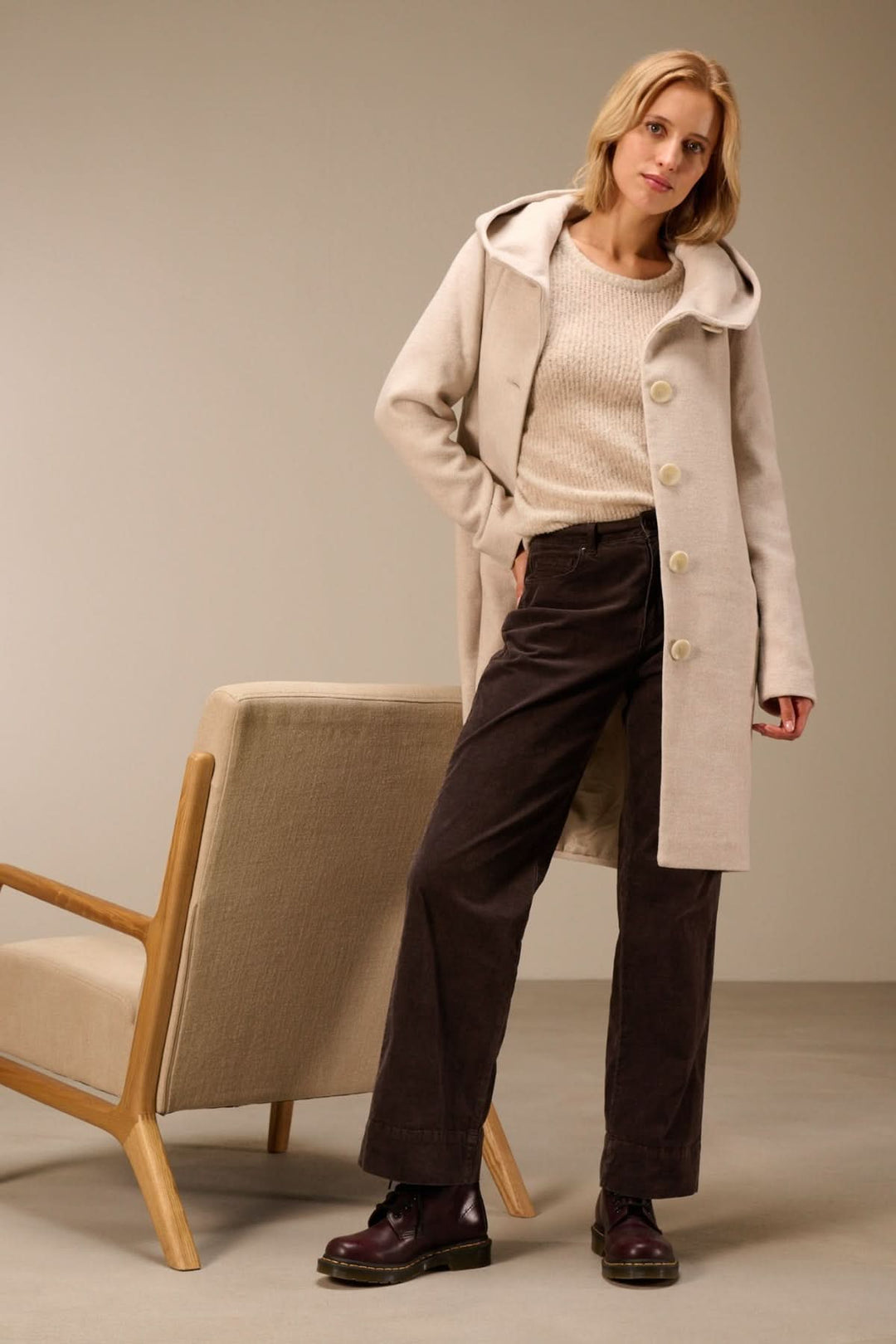 Modèle portant un pantalon en velours côtelé coupe droite avec manteau beige et chandail, style décontracté et élégant.