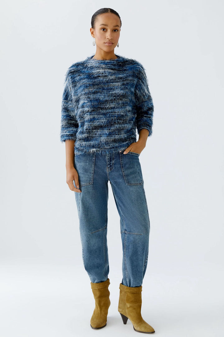 Chandail court moelleux tricoté avec manches 1/2, porté avec un pantalon bleu et des bottines jaunes.