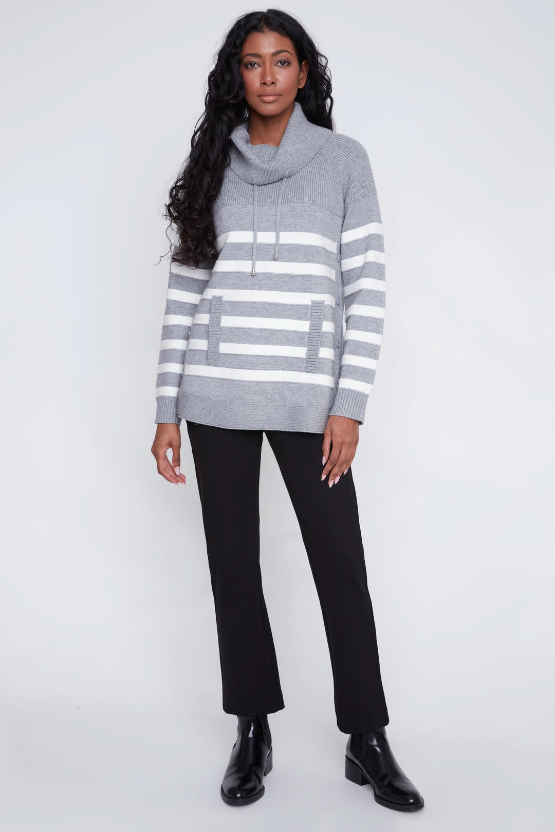 Chandail rayé gris avec col bénitier et poche frontale, porté avec pantalon noir pour un look décontracté chic.