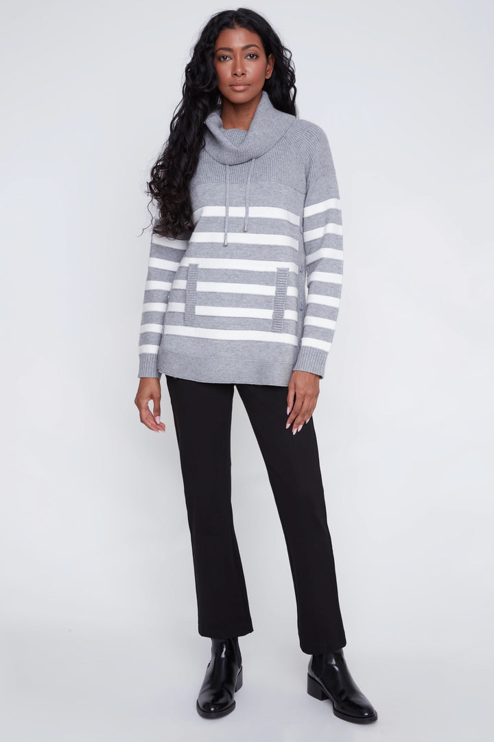 Chandail rayé gris avec col bénitier et poche frontale, porté avec pantalon noir pour un look décontracté chic.