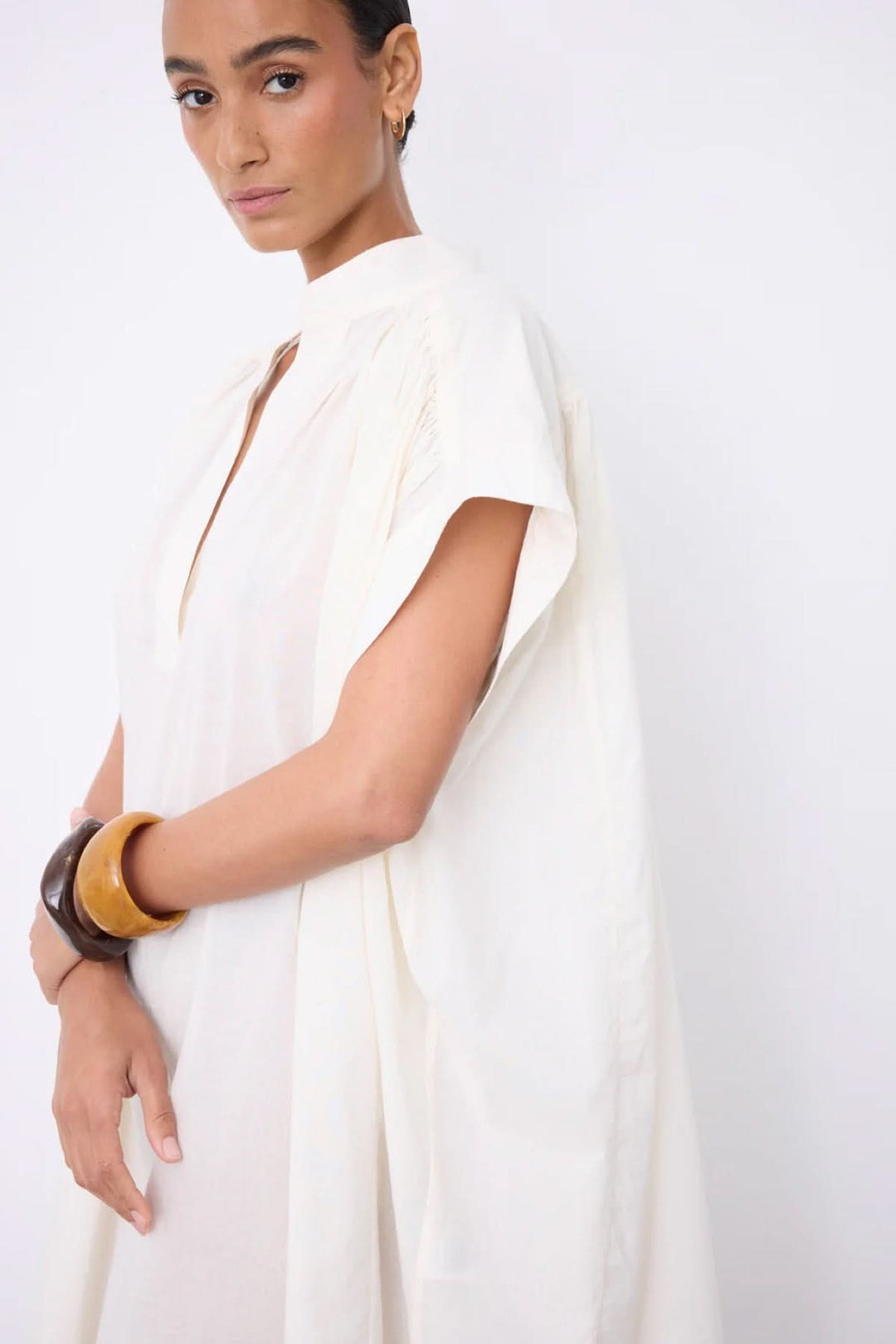 Robe Fani courte fluide col ouvert, tenue épurée et élégante avec encolure en V, manches courtes. Idéale pour un look minimaliste.