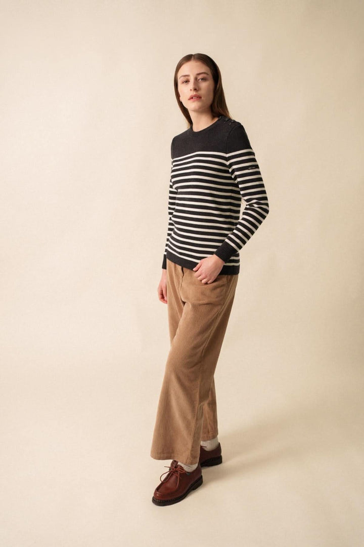 Chandail Rochefort R F en laine mérinos avec rayures marines, porté avec un pantalon en velours beige.