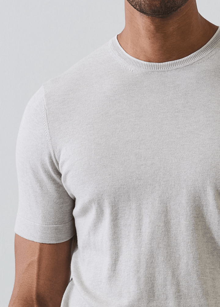 Homme portant un T-shirt en coton et cachemire avec finition discrète au col, t-shirt en maille fine pour une allure moderne et soignée.