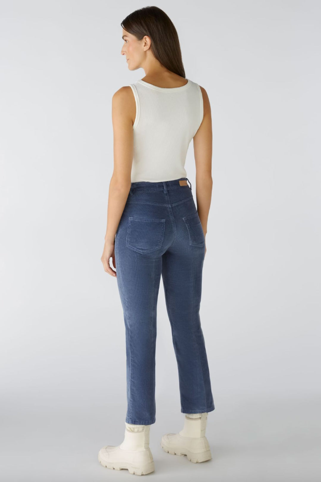 Femme avec pantalon en velours côtelé, coupe légèrement évasée au bas, vue arrière, style décontracté.