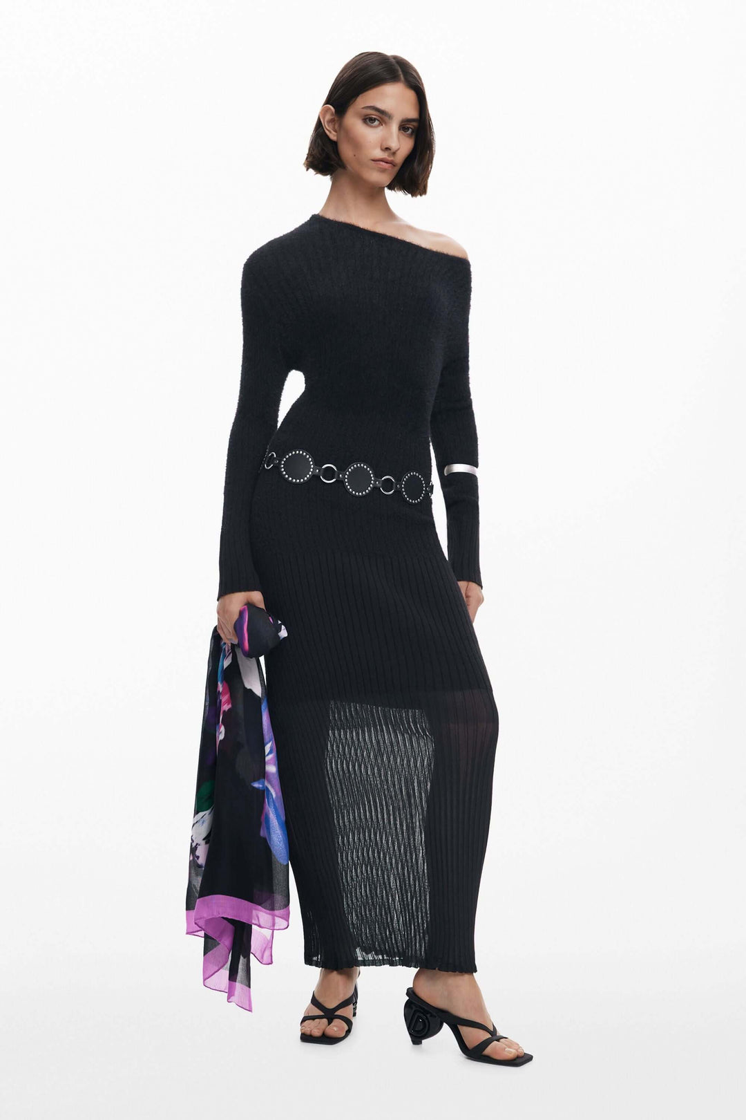 Femme portant un foulard rectangulaire à fleurs multicolores avec liseré contrasté, accessoire élégant et polyvalent.