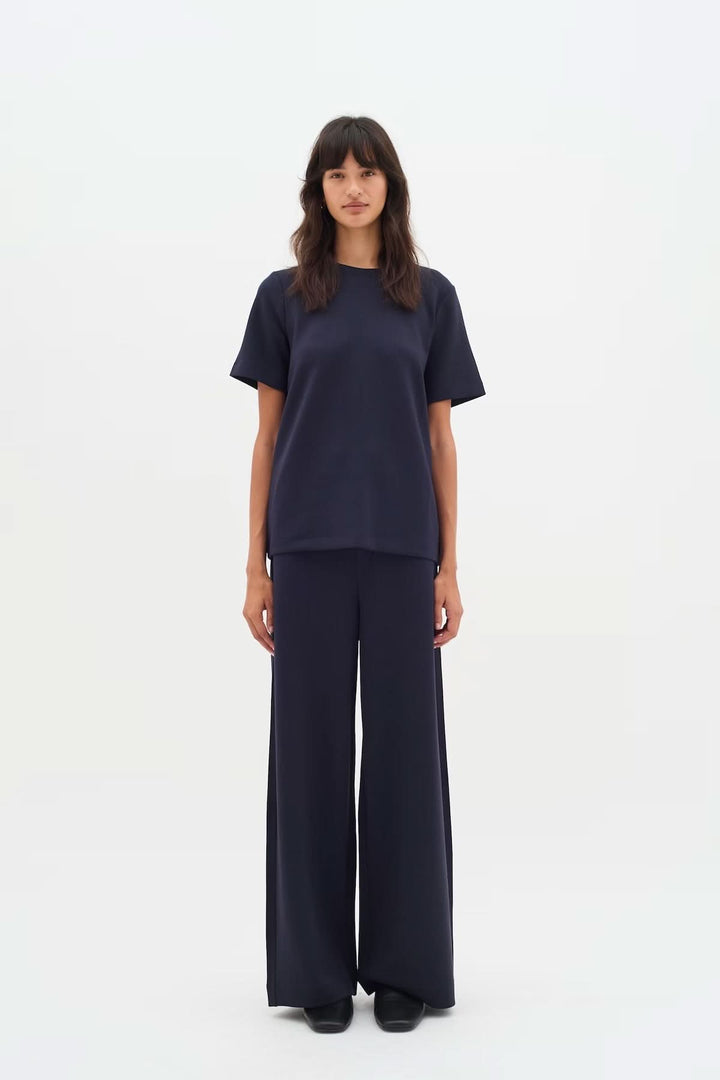 Femme portant un Pantalon à jambe large Gincette bleu marine, offrant une silhouette fluide et élégante avec une coupe ample.