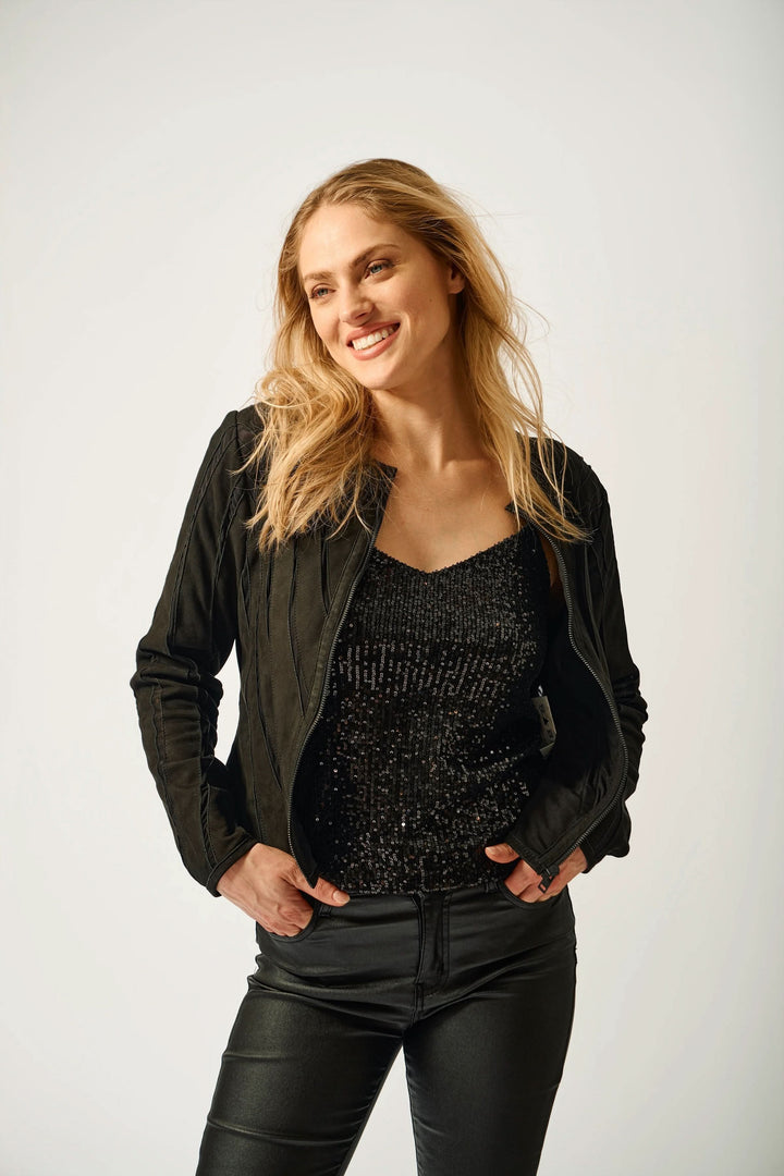 Femme portant le Manteau Mira en cuir, style moderne avec col rond. Associez-le à un jean pour un look épuré et minimaliste.
