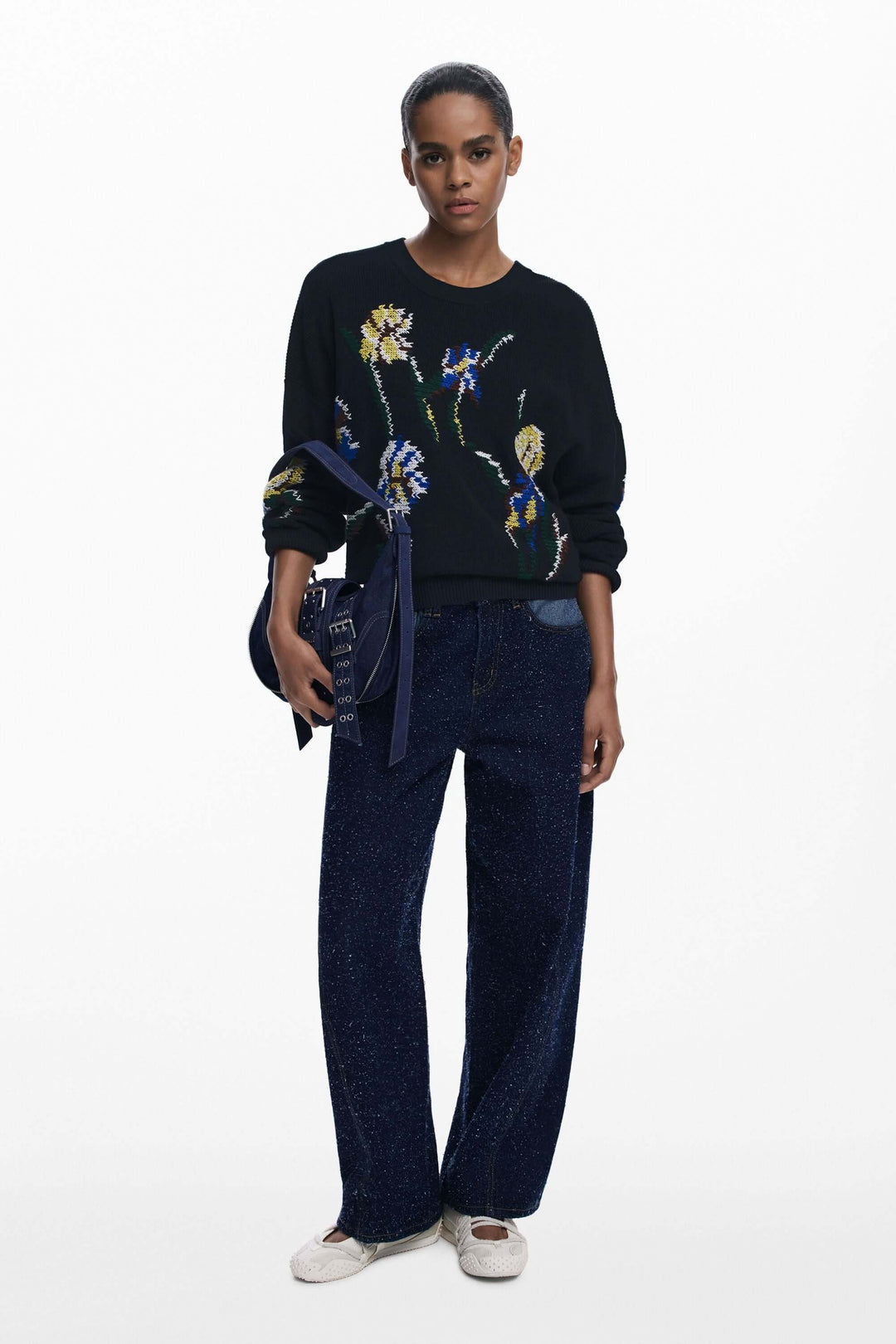 Modèle portant un Chandail à fleurs brodées avec motifs floraux colorés, combinant confort et style décontracté et élégant.