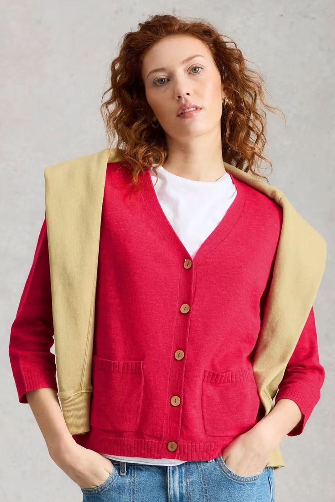 Femme portant un cardigan en maille à col v boutonné avec une encolure en V et poches plaquées, style moderne et polyvalent.