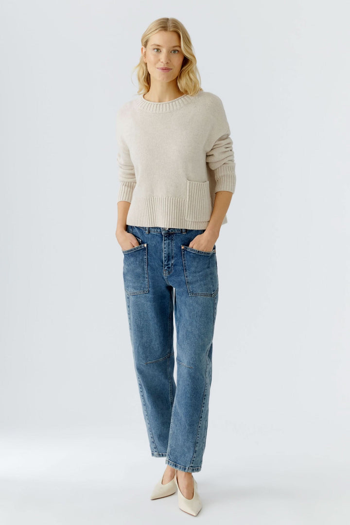 Chandail en maille fine avec poche plaquée, porté avec un jean décontracté, style moderne et polyvalent.