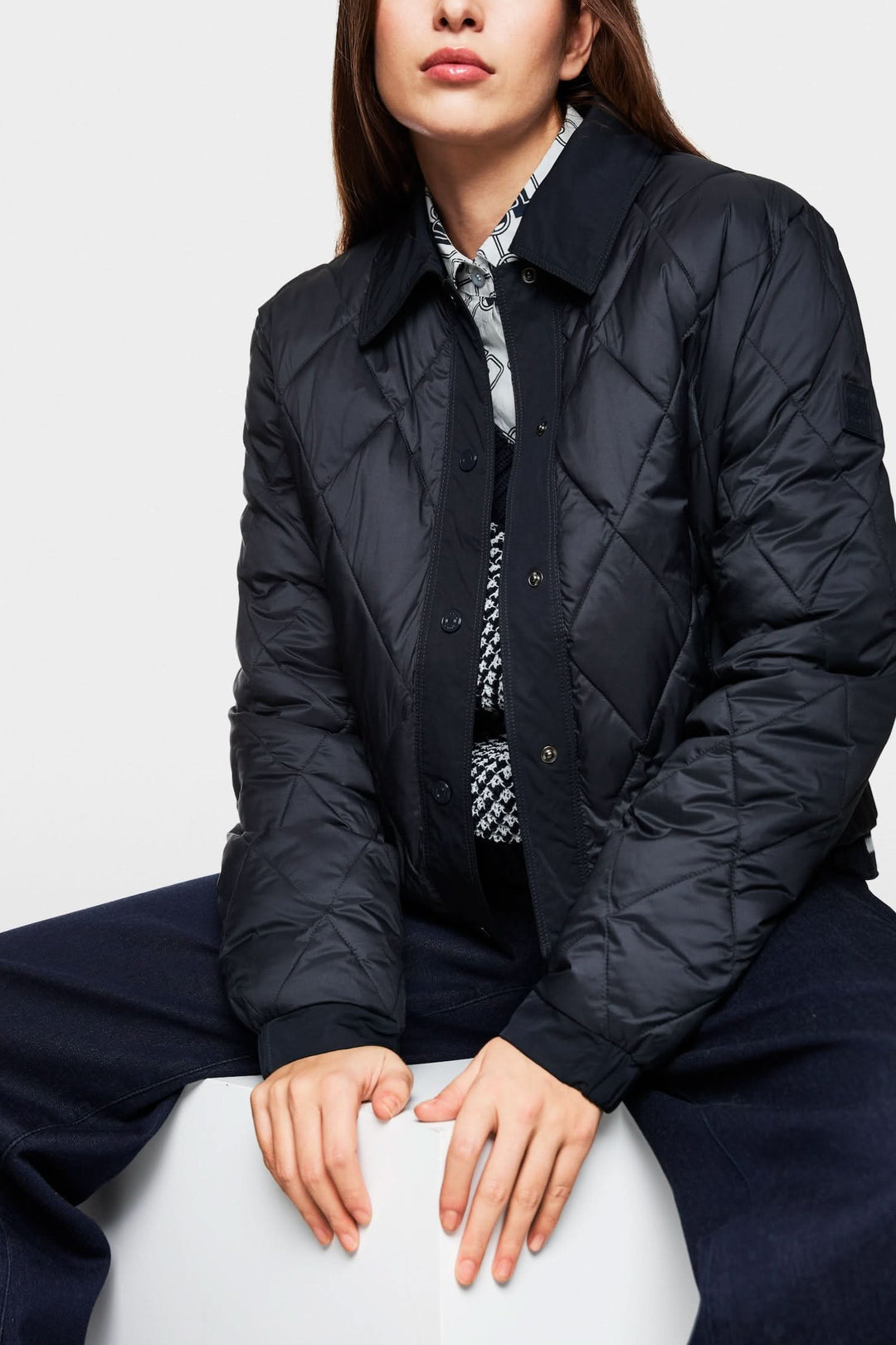 Veste matelassée noire au design épuré, fabriquée en fibres recyclées pour un style écoresponsable.