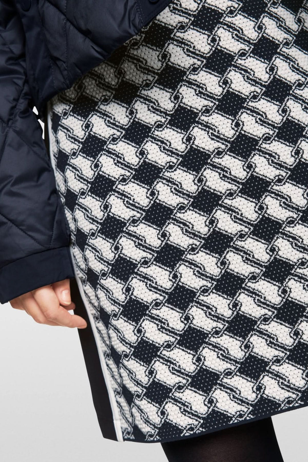 Jupe en maille avec motif cubique audacieux et taille élastique, vêtue avec une parka noire.