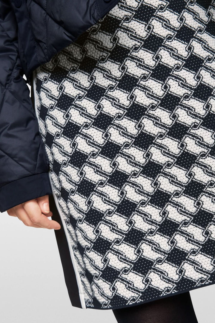 Jupe en maille avec motif cubique audacieux et taille élastique, vêtue avec une parka noire.