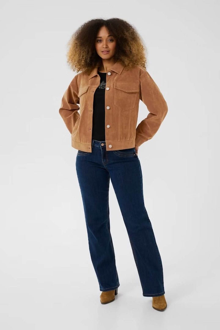 Femme portant une veste en suédine marron avec des poches, associée à un jean foncé pour un look casual chic.