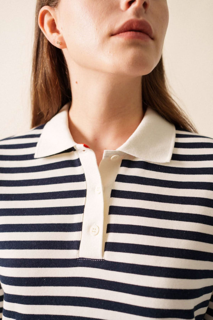 Détail du col polo classique d'un chandail NINA à rayures bleues et blanches, mettant en valeur un look décontracté.