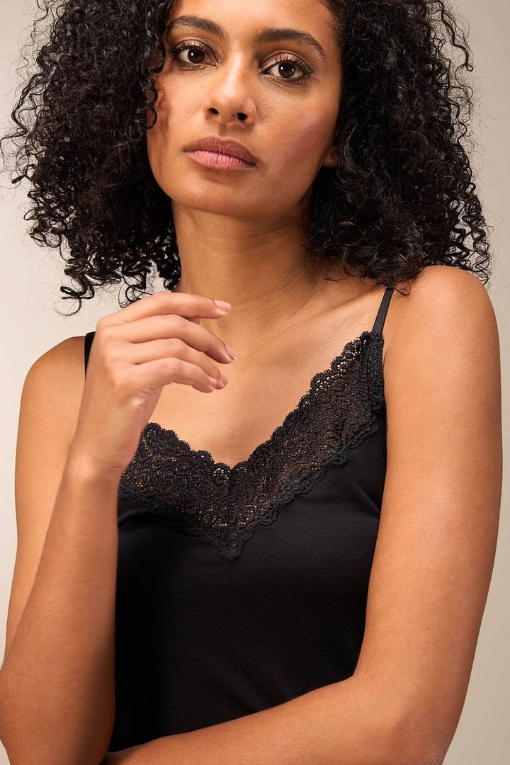 Camisole noire avec dentelle délicate, fines bretelles et coupe ajustée, pour un style élégant et féminin.