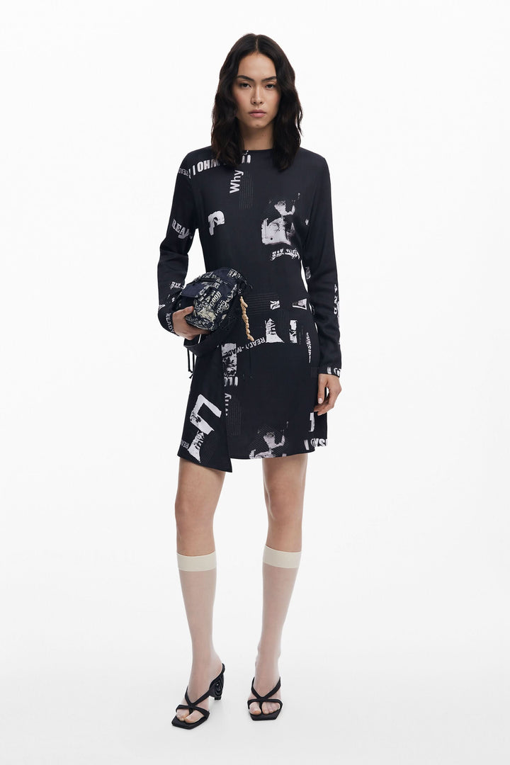 Robe manches longues avec imprimé typographique noir et blanc, style urbain, portée avec des bas et des talons.