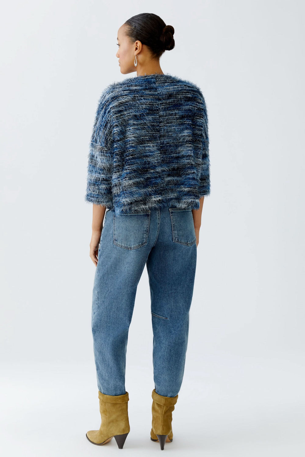 Chandail court en tricot moelleux, vue arrière, porté avec des jeans et des bottes jaunes.