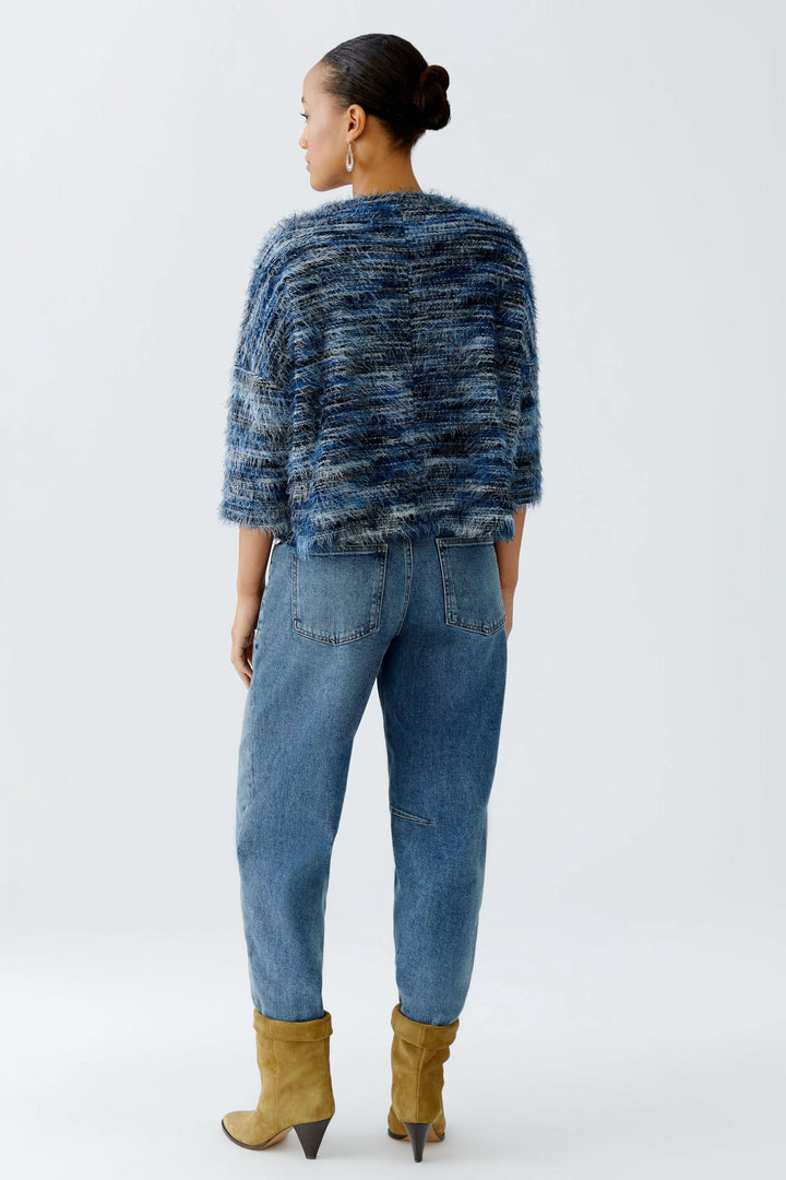 Chandail court en tricot moelleux, vue arrière, porté avec des jeans et des bottes jaunes.