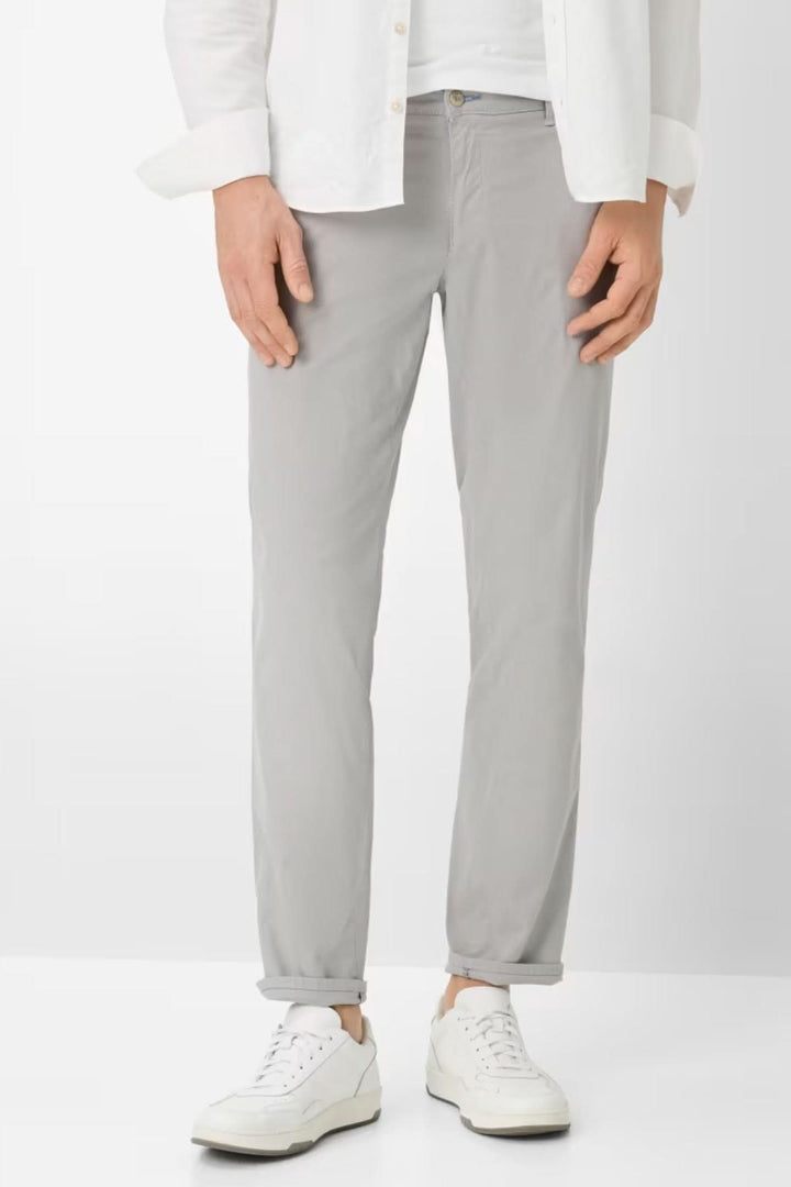 Homme portant le Pantalon style Fabio en gris, coupe droite avec fermeture à bouton, poches latérales, idéal pour un style moderne