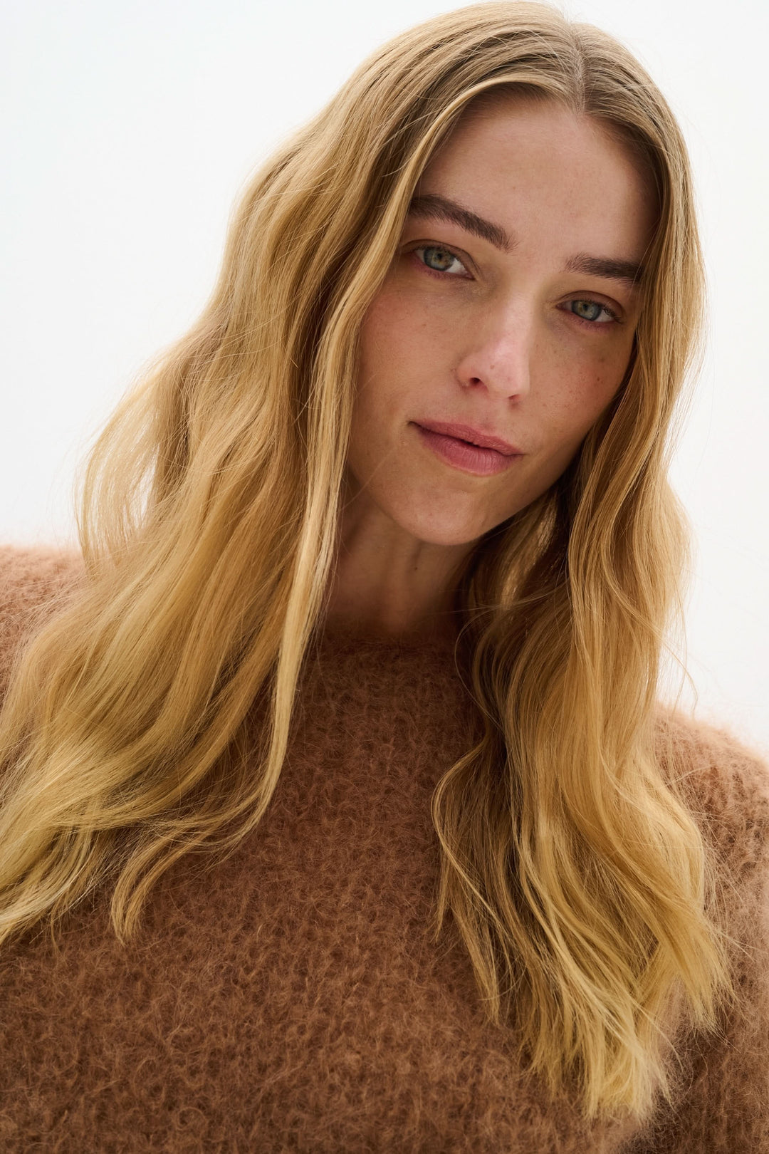 Modèle portant un chandail en maille duveteuse, affichant un look cosy et élégant avec une texture aérienne.
