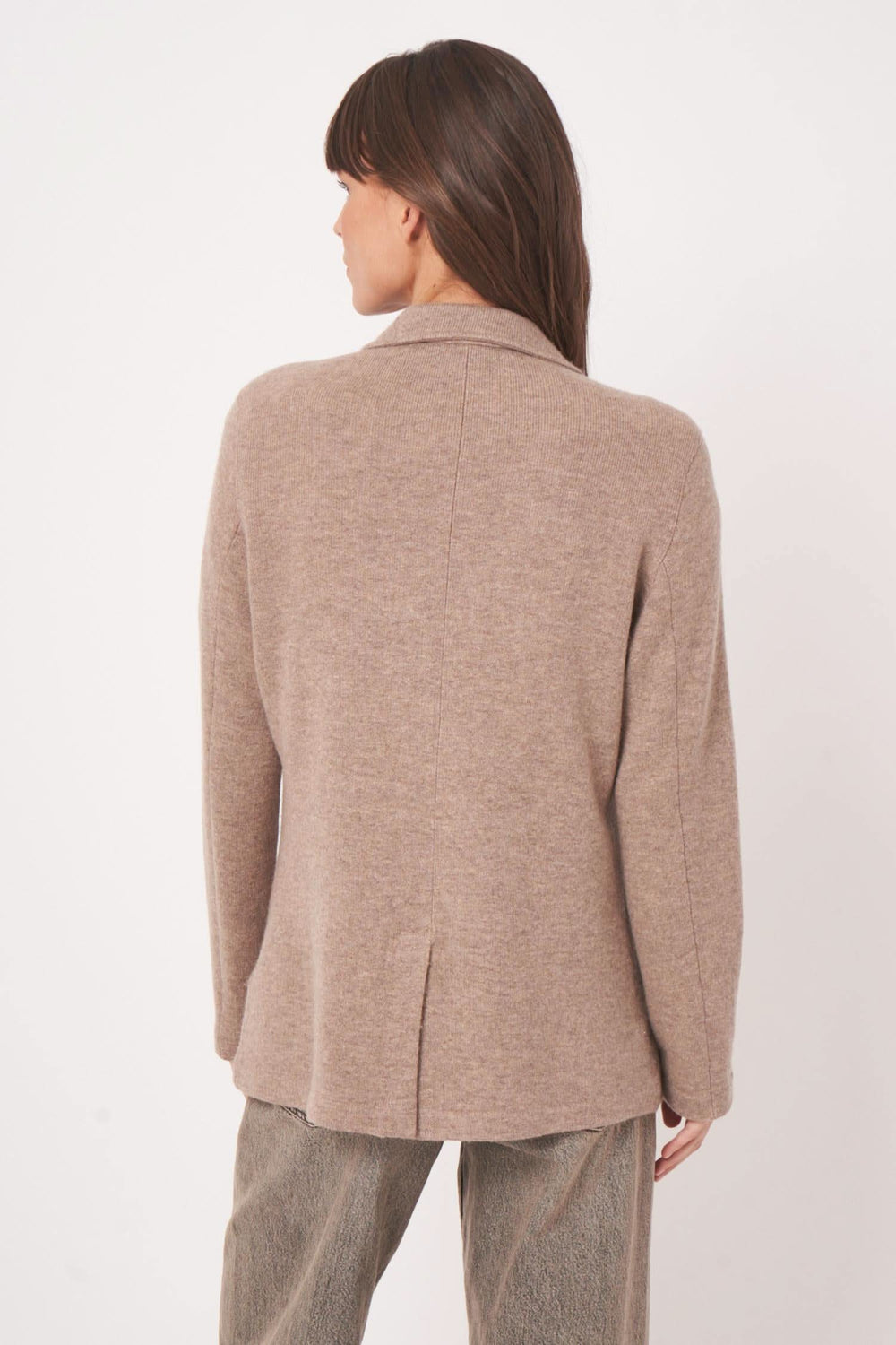 Veston en maille beige sur mannequin, présentant une coupe droite et un tissu doux en laine et cachemire.
