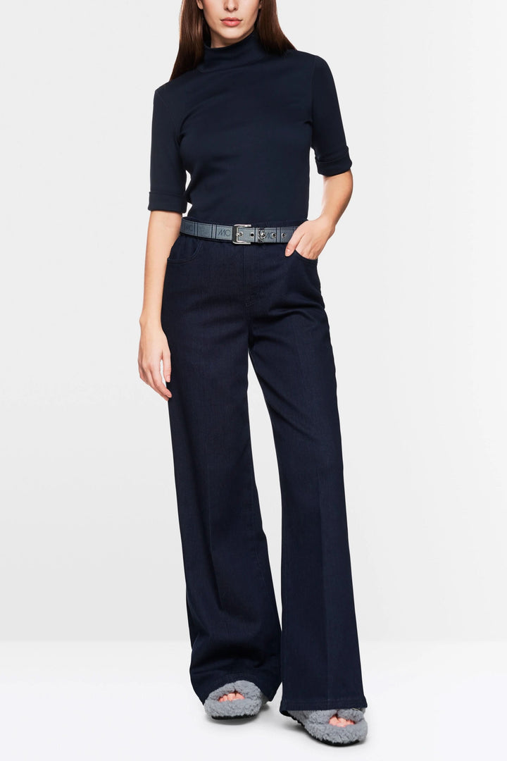 Modèle féminin portant un t-shirt basique à col montant et un pantalon large, style minimaliste et chic.