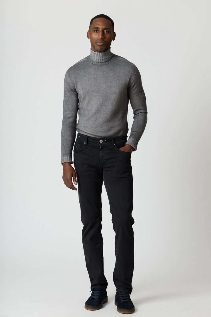 Homme portant Jean 5 poches stretch coupe moderne, pull gris et sneakers noires, illustrant confort et style urbain soigné.